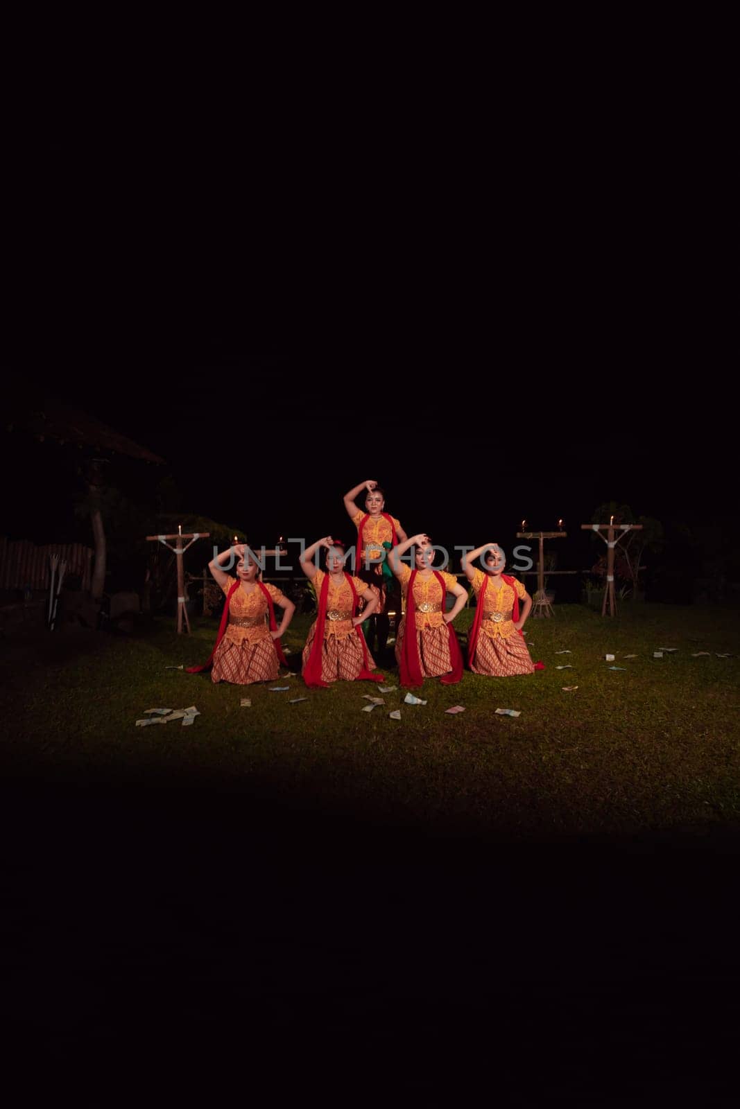 Asian dancers take pose with dance movements while performing the traditional dance in the competition during the night