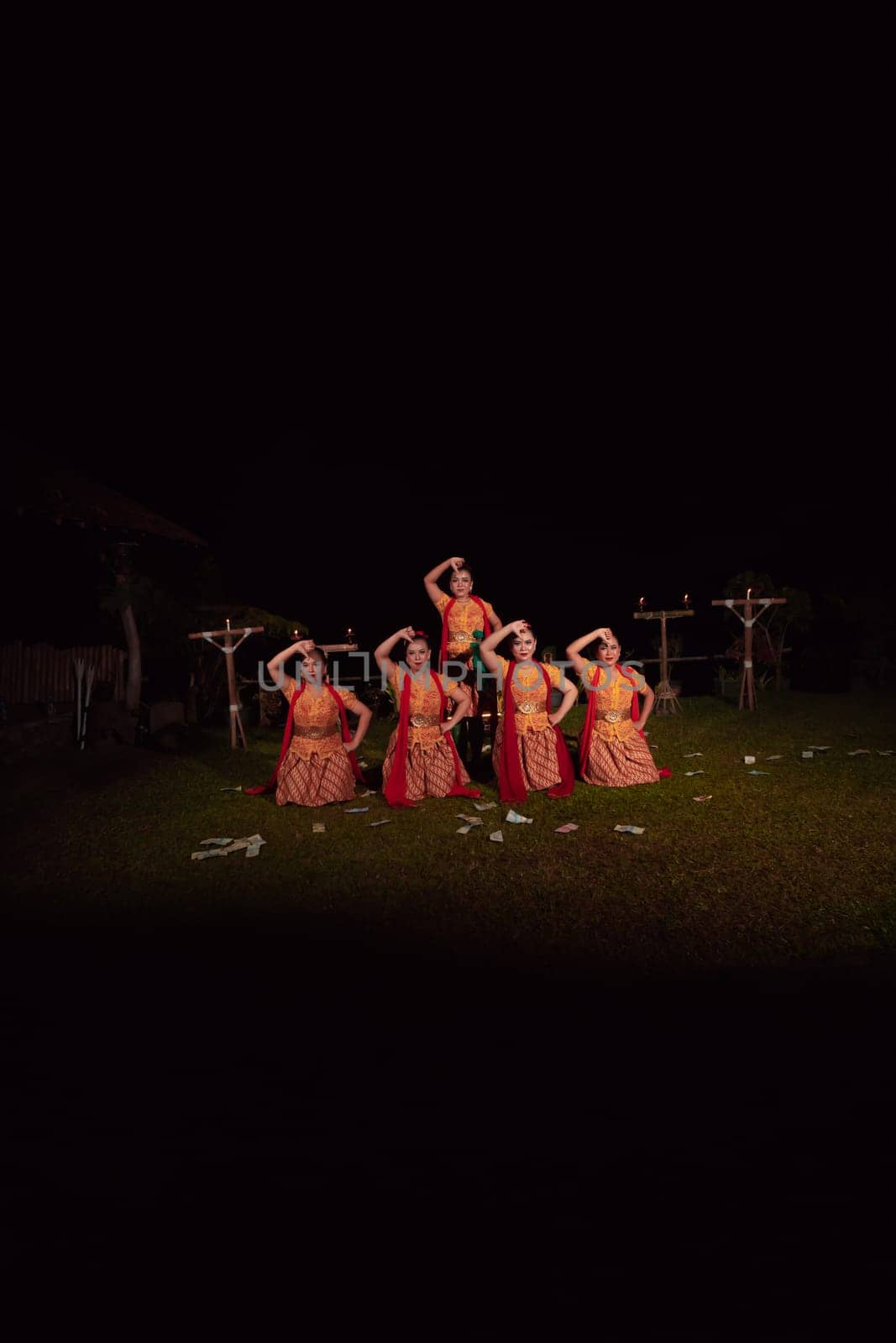 Asian dancers take pose with dance movements while performing the traditional dance in the competition during the night