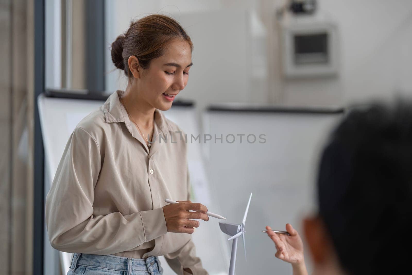 A young woman presenting a sustainable business strategy focused on ESG principles in a modern office setting.