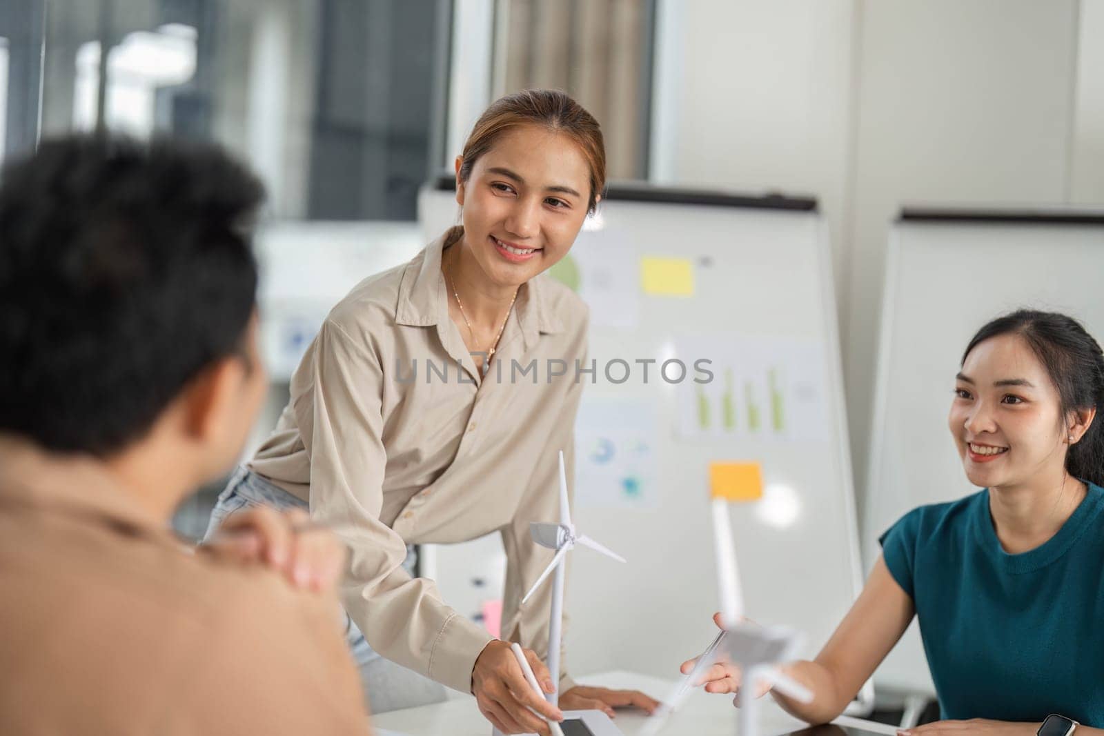 A young woman presents her ideas on ESG goals to her colleagues, fostering a collaborative environment.