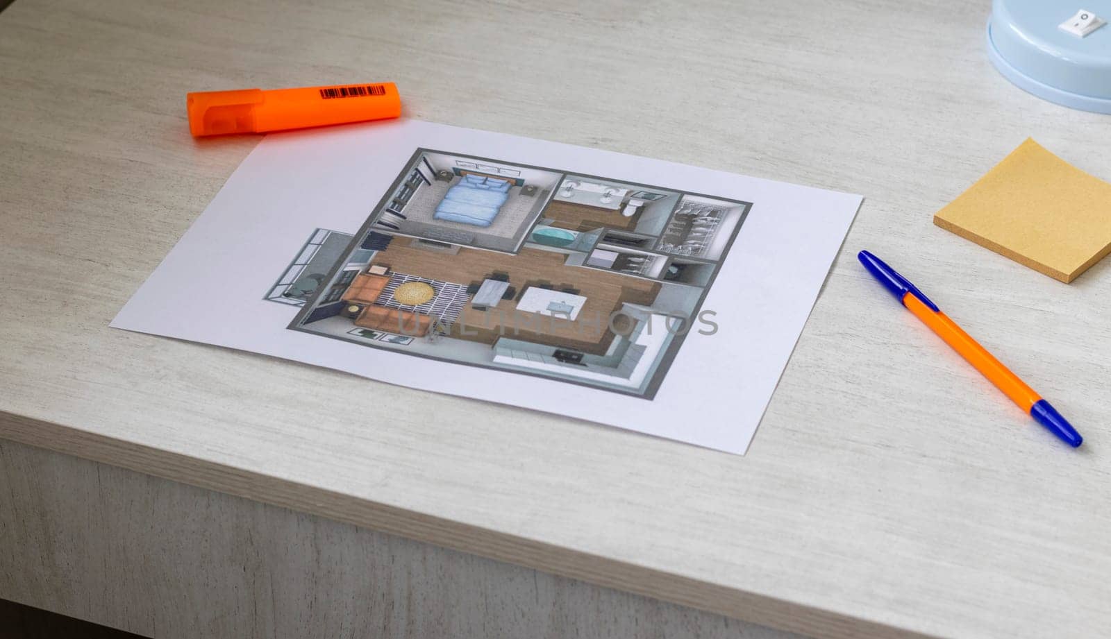 Layout of the small, furnished apartment printed on the sheet of paper placed on the desk