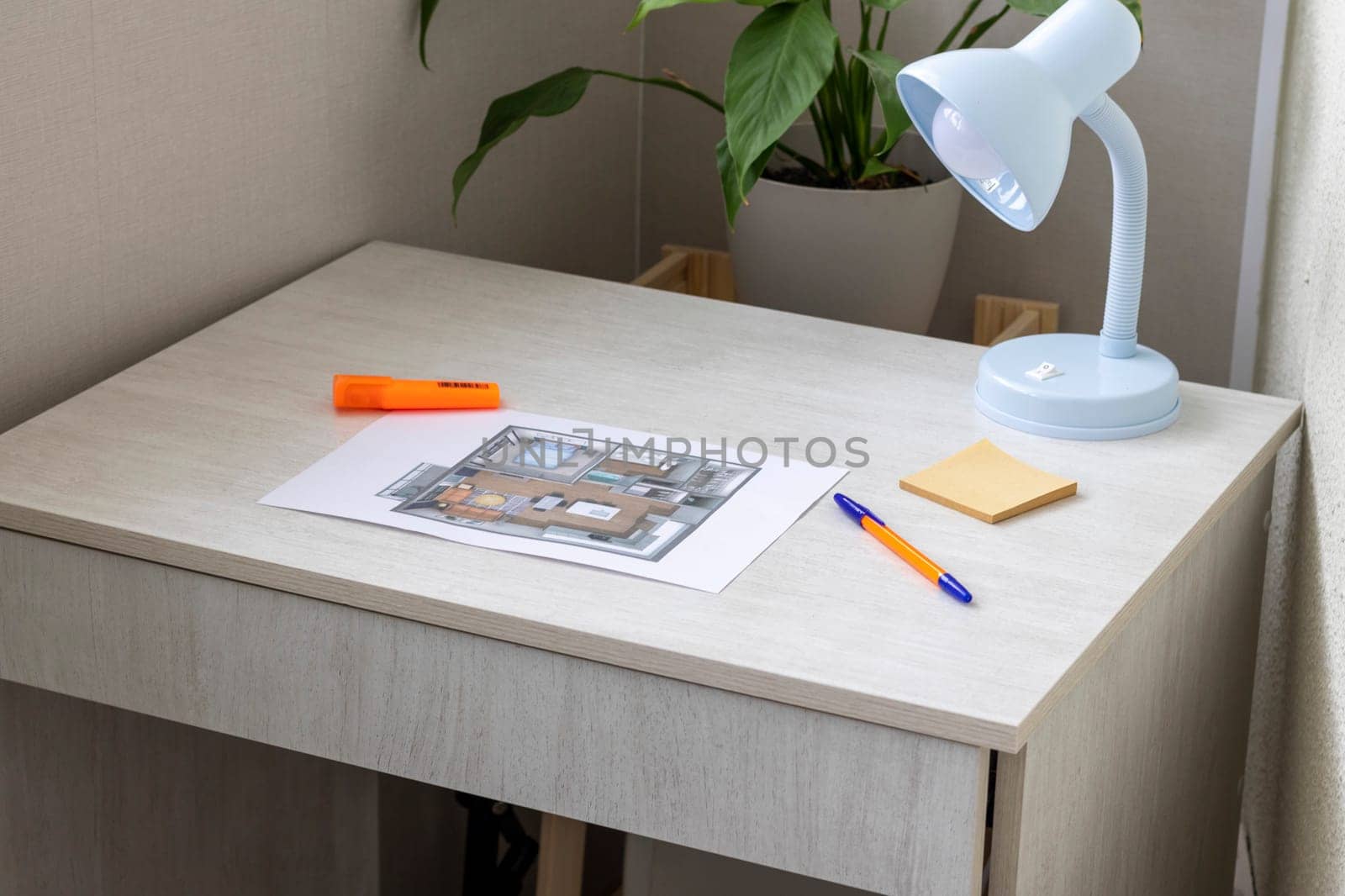 Layout of the small, furnished apartment printed on the sheet of paper placed on the desk