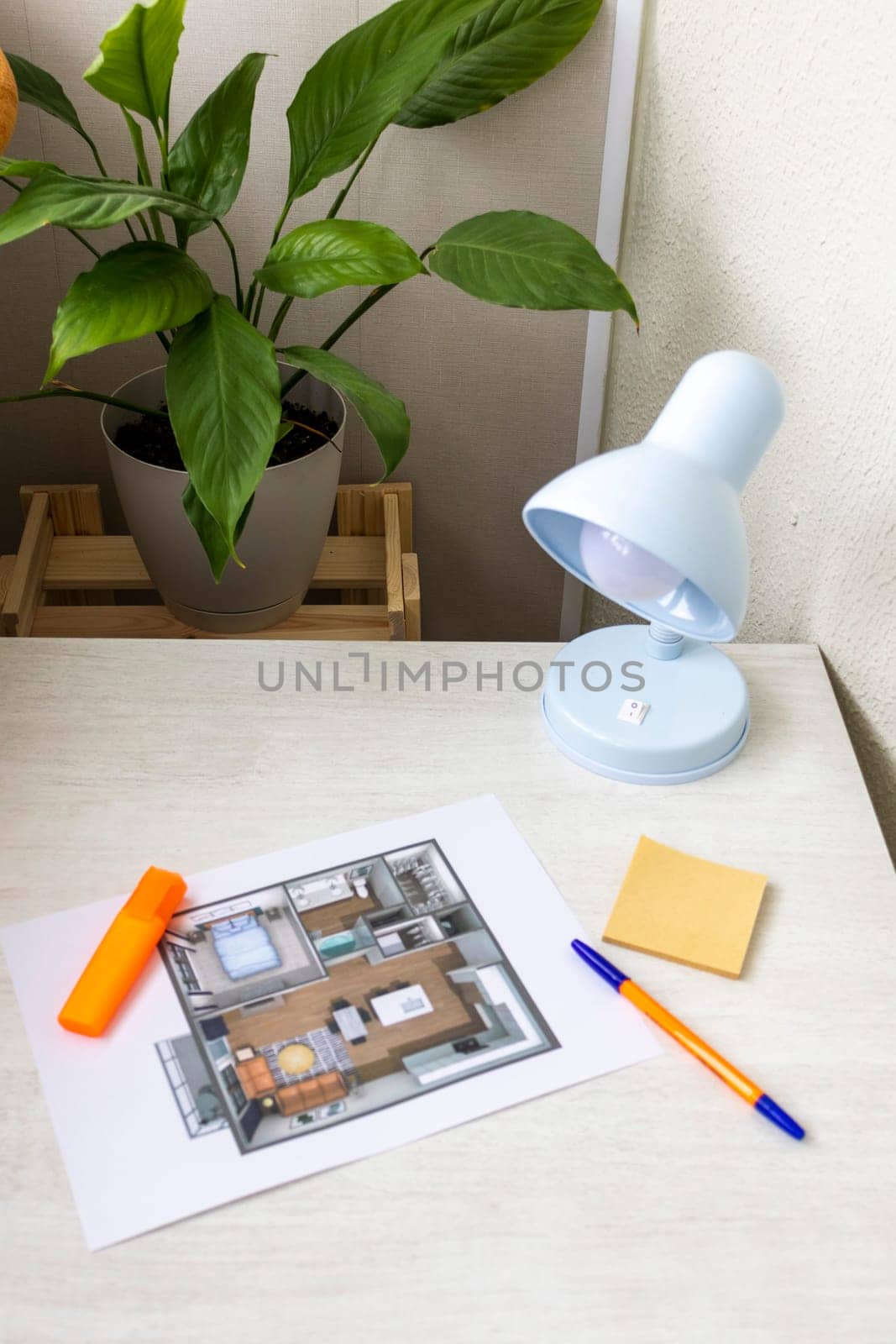 Layout of the small, furnished apartment printed on the sheet of paper placed on the desk