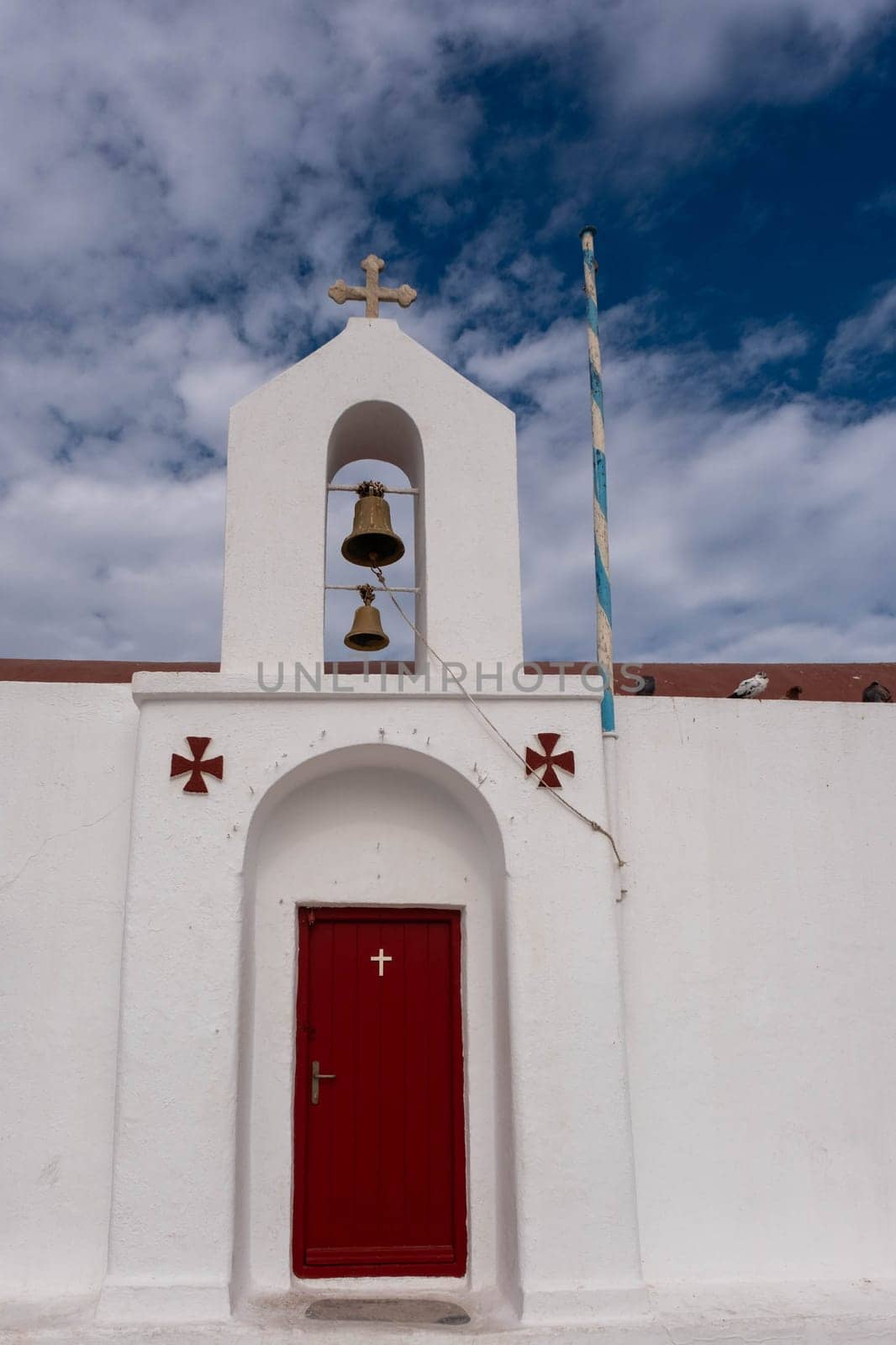 MYKONOS, GREECE - October 19, 2024: Red Door in White Church in Mykonos Greece