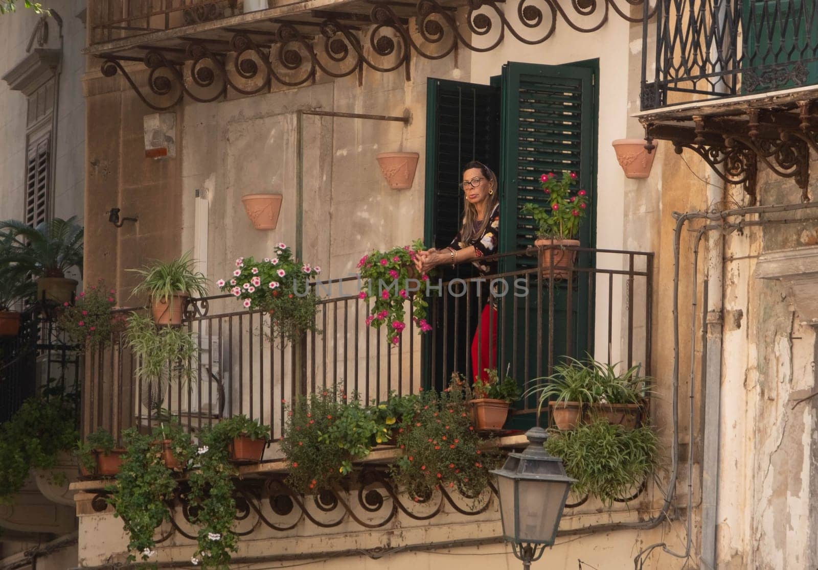 PALERMO, ITALY - October 24, 2024: Woman on Balcony in Palermo Italy