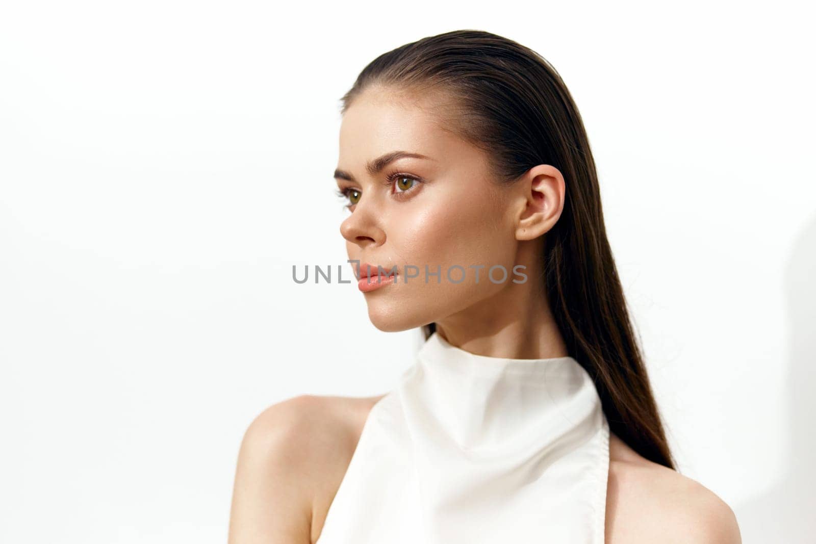 A poised female model with straight hair, dressed in a minimalist white outfit, exudes calmness. Ideal for fashion, beauty, and lifestyle projects, capturing elegance and sophistication.