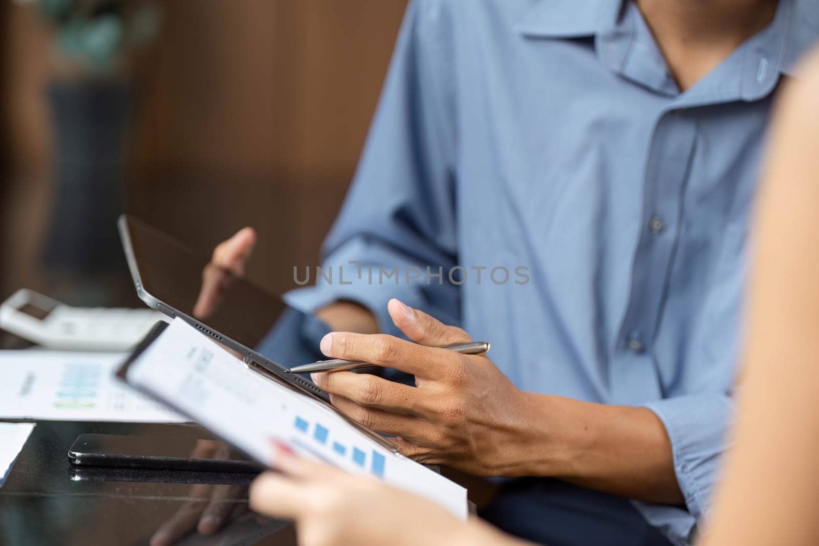 Two young professionals engaged in a detailed analysis of financial data, collaborating effectively in a modern office environment.