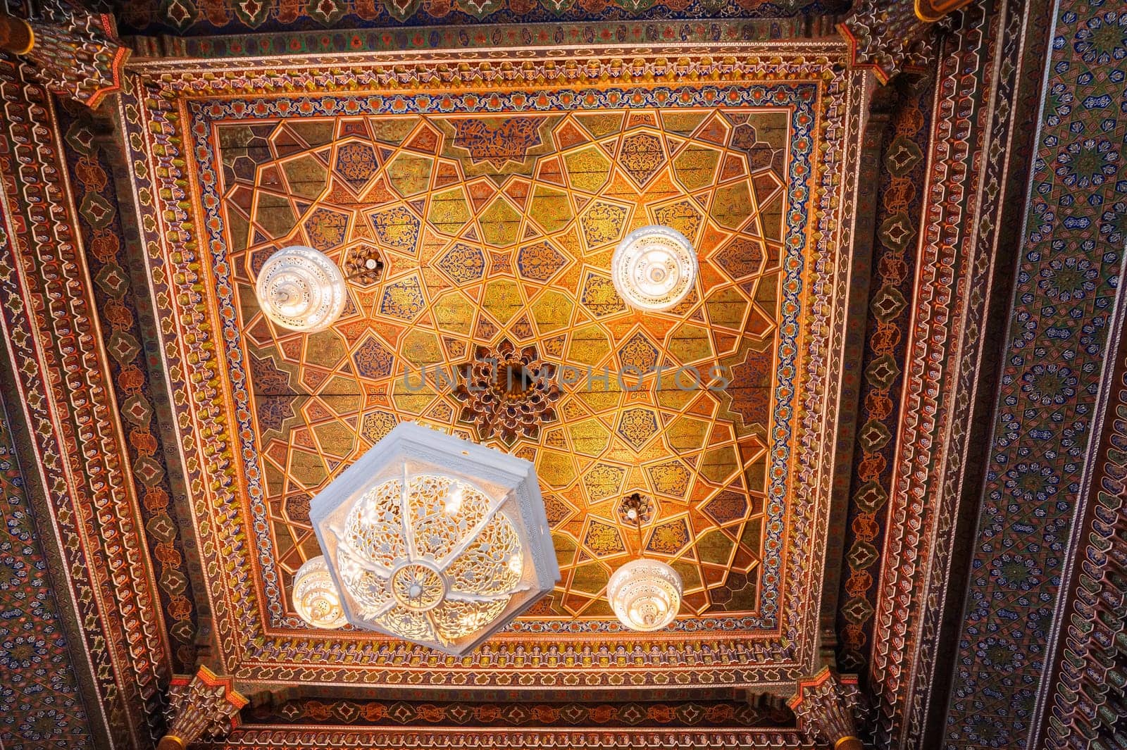 beautiful carved wooden painted ceiling with vintage chandelier in Museum of Art of Uzbekistan with traditional Uzbek ornaments and colorful oriental patterns in Uzbekistan