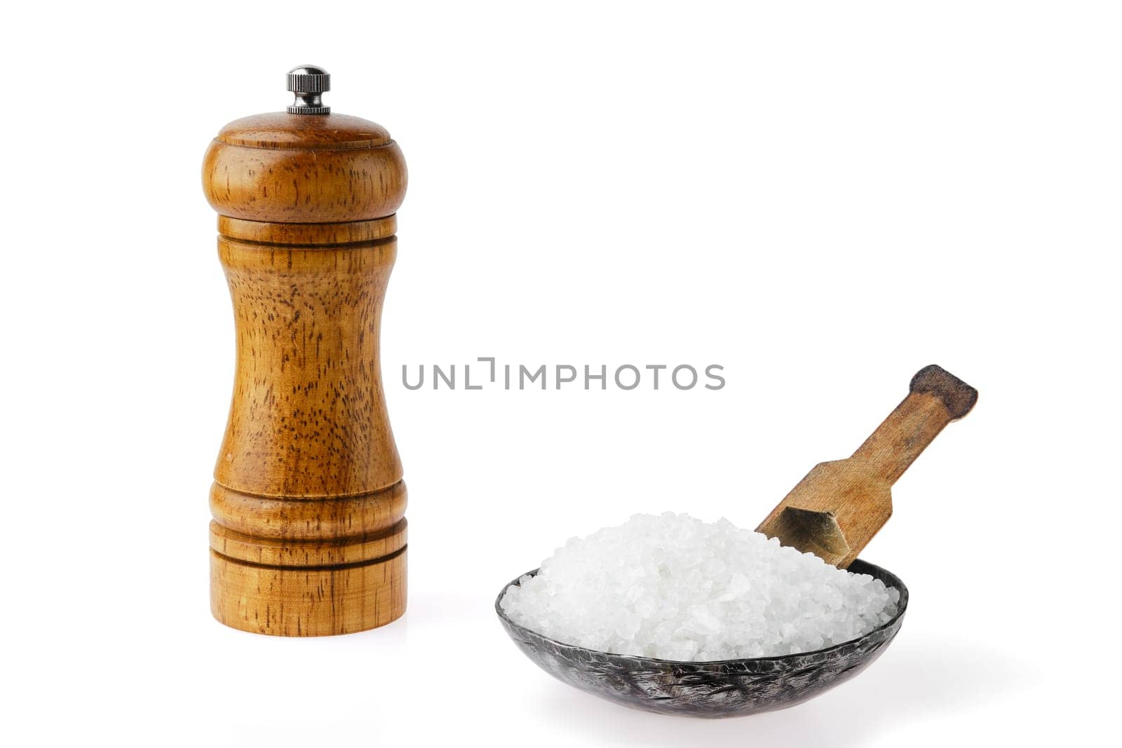 A wooden pepper grinder stands next to a bowl filled with coarse sea salt, accompanied by a wooden scoop. The contrasting textures showcase the simplicity of seasoning essentials for culinary use.