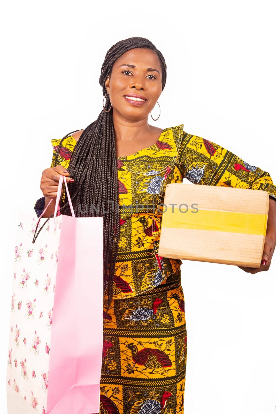 beautiful adult woman standing holding a bag and a paper cardboard in her hand being happy