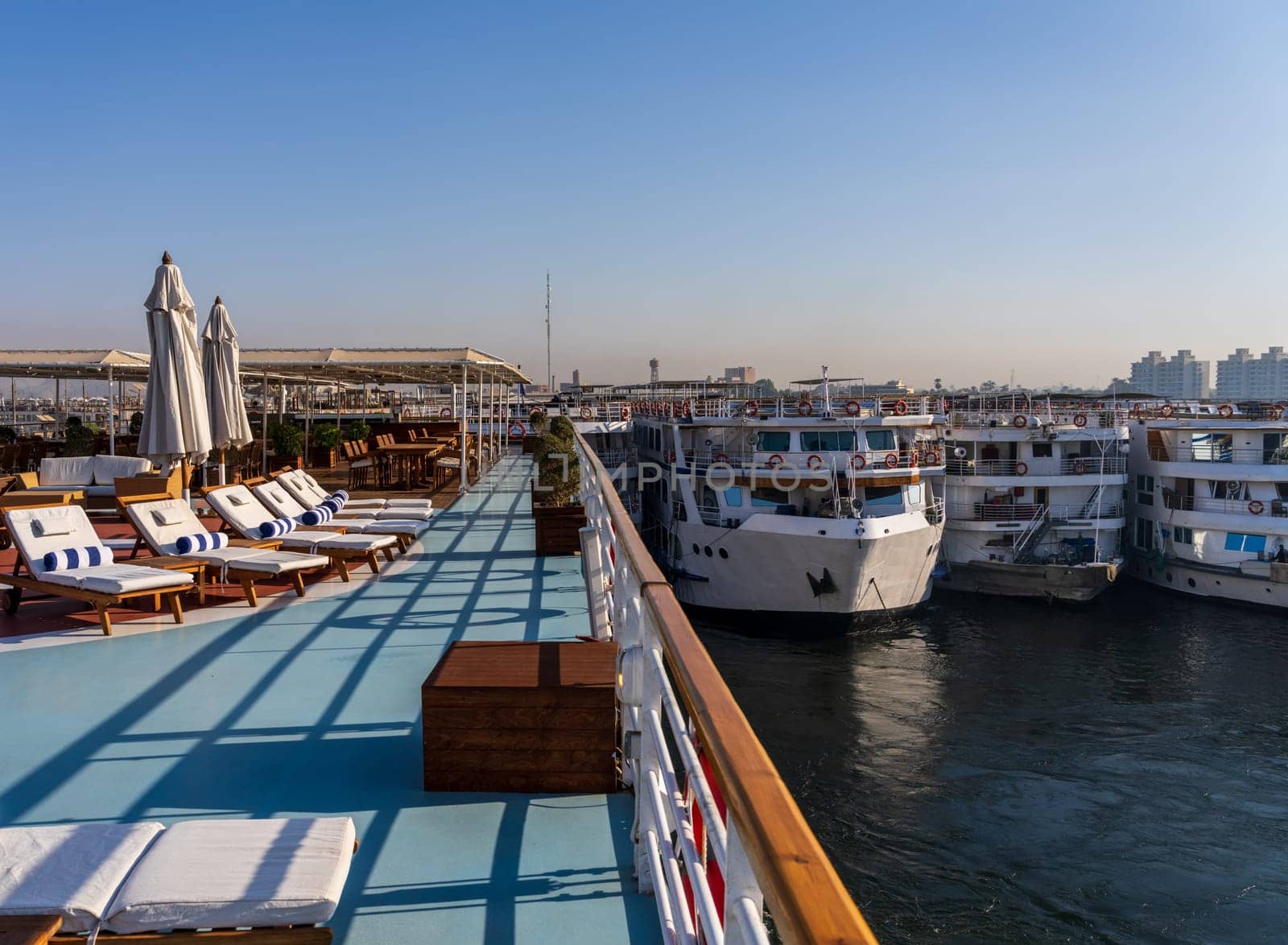 Many cruise ships docked side by side seen from deck of Nile cruise boat in congested Edfu harbor Egypt