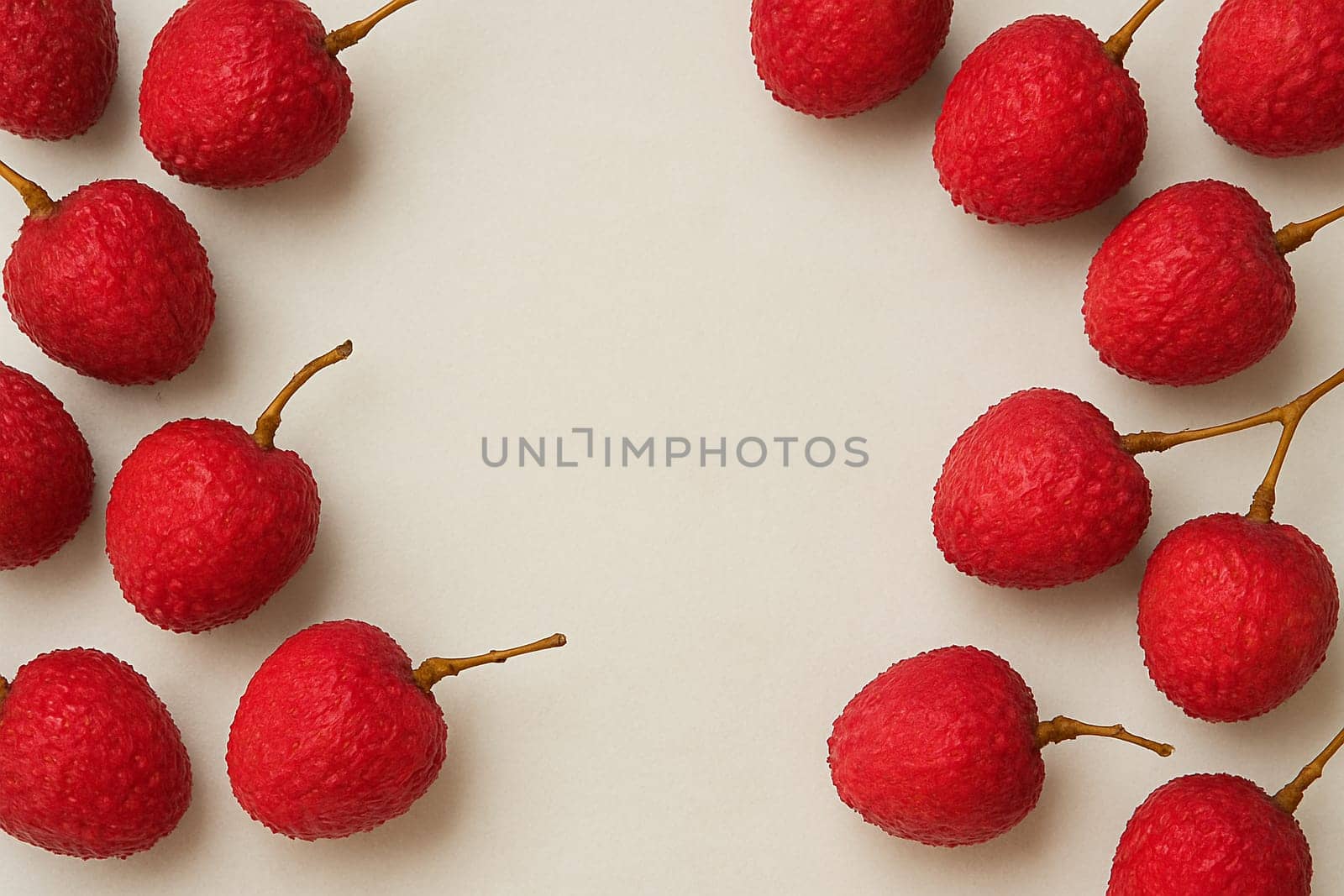 AI generated vibrant image of ruby-red lychees arranged in circular formation with glistening water droplets, showcasing their textured pink-red shells and fresh stems against clean white background