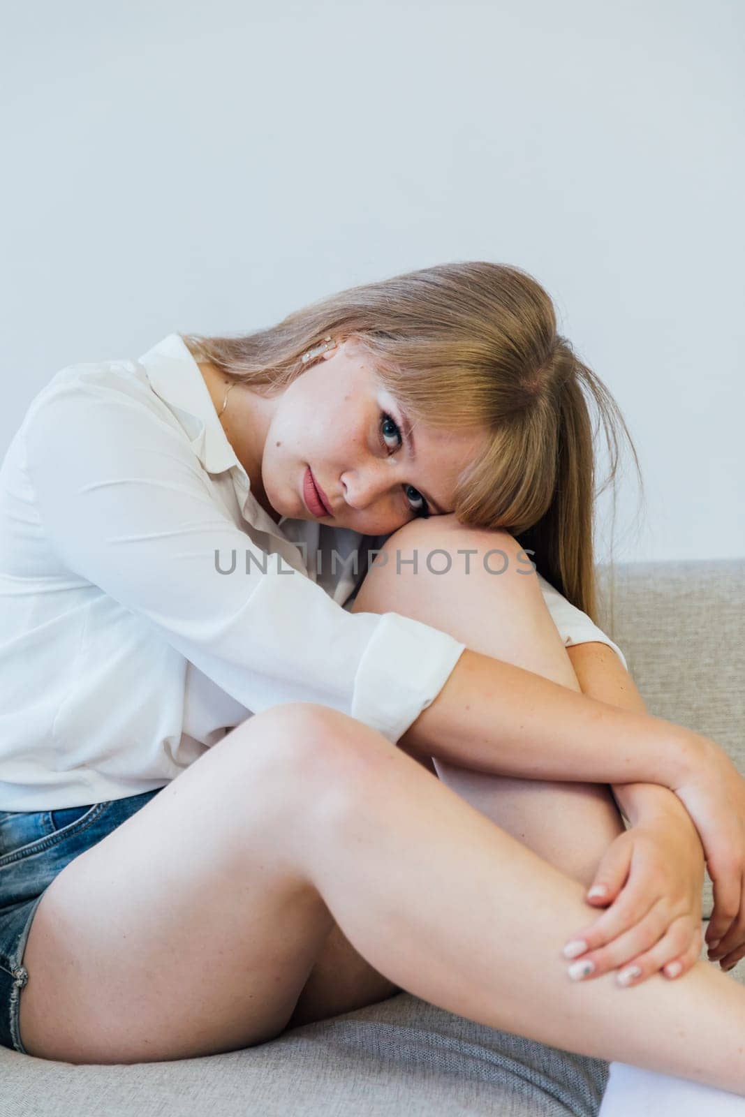 Woman sitting on sofa in white room interior