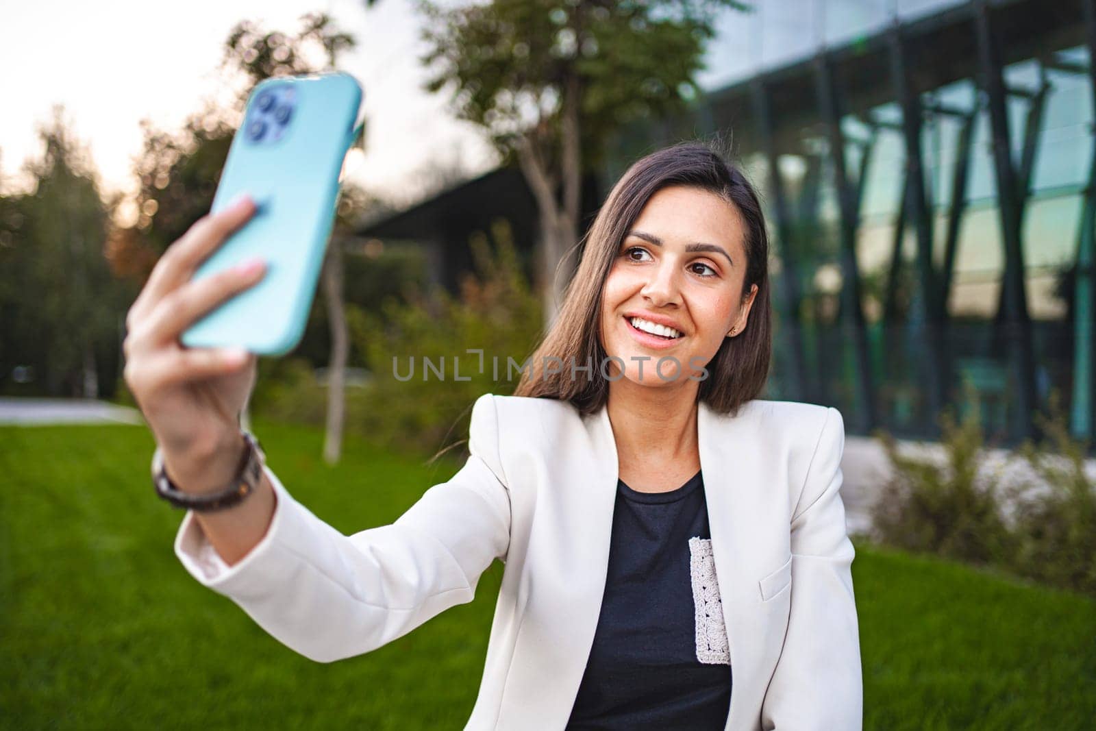 Businesswoman taking selfies on a phone after work.