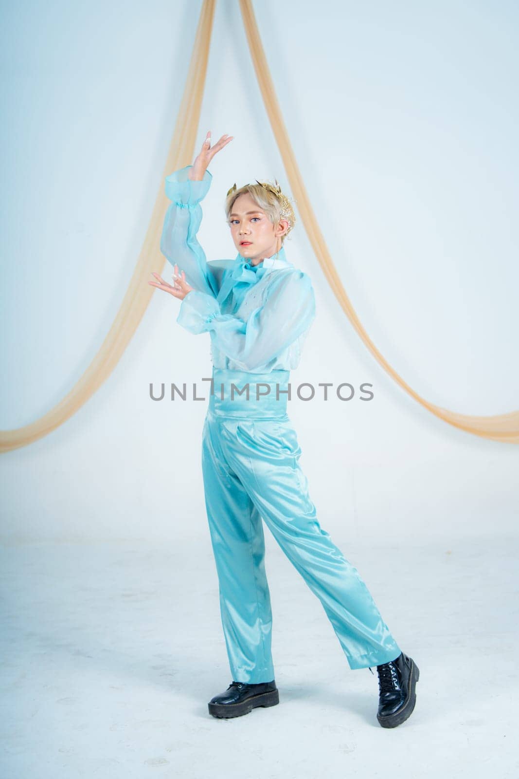 an Asian woman with blonde hair posing with her hands in a white studio