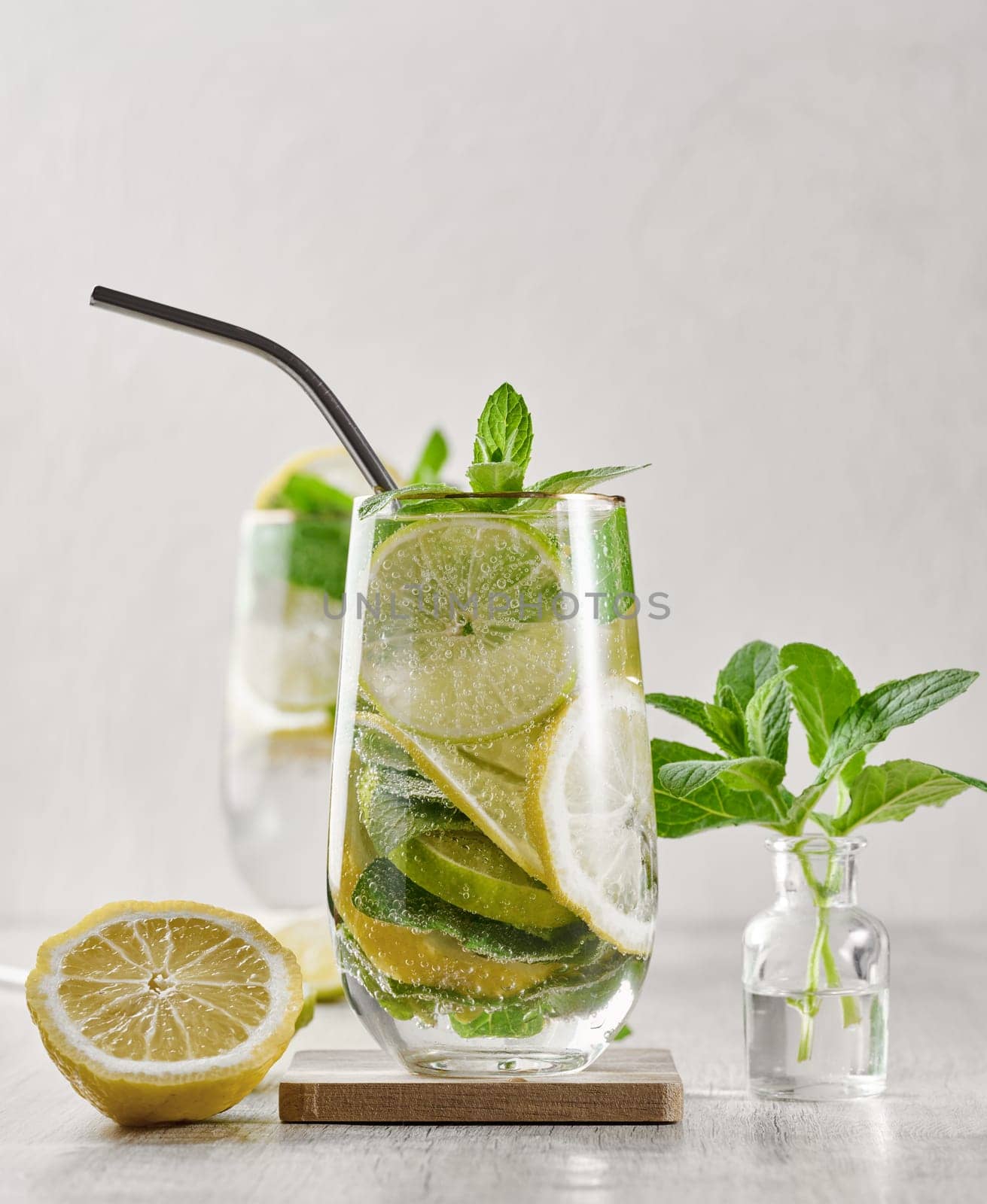 Summer drink with lime and mint. Cold drink, non-alcoholic mojito or lemonade, garnished with fresh mint sprigs and citrus slices. 