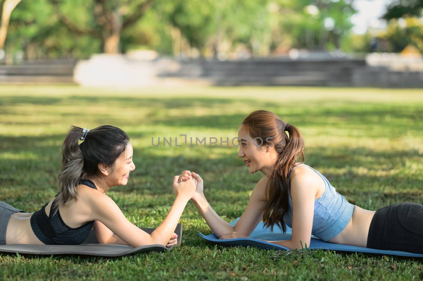 Healthy lifestyle concept with two cheerful friends exercising together outdoors.