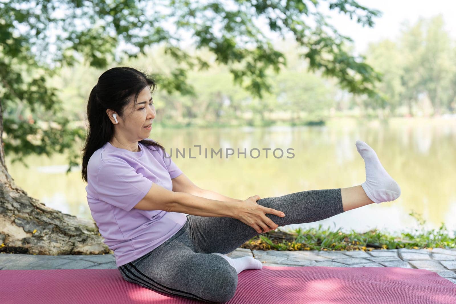 A woman engages in yoga stretches near a serene lake, promoting wellness and mindfulness in nature.