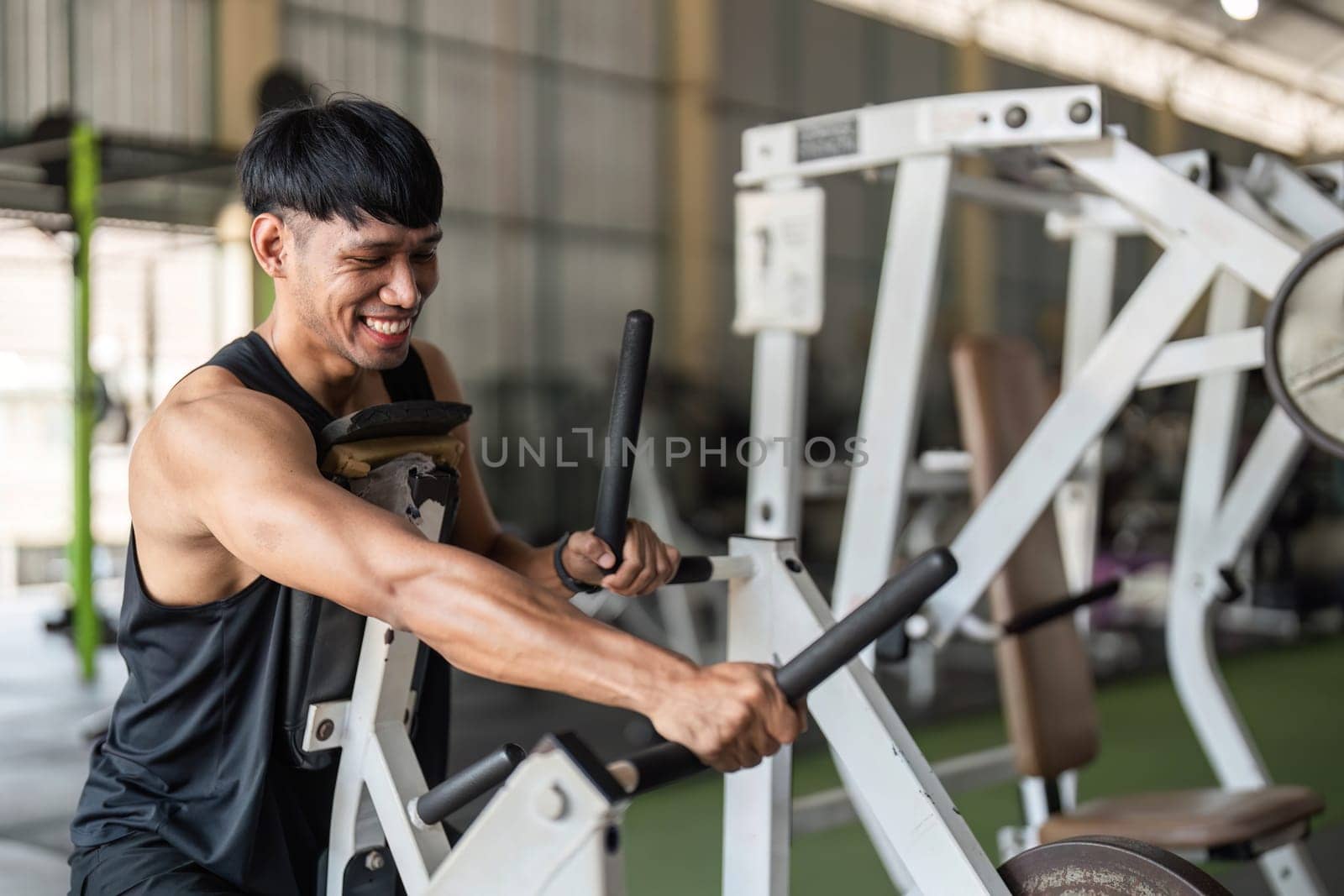 A male athlete passionately works out on gym equipment, focusing on strength training and fitness goals.