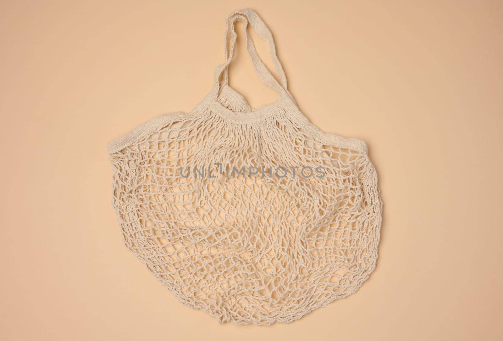 Empty reusable cotton mesh bag on neutral background, top view