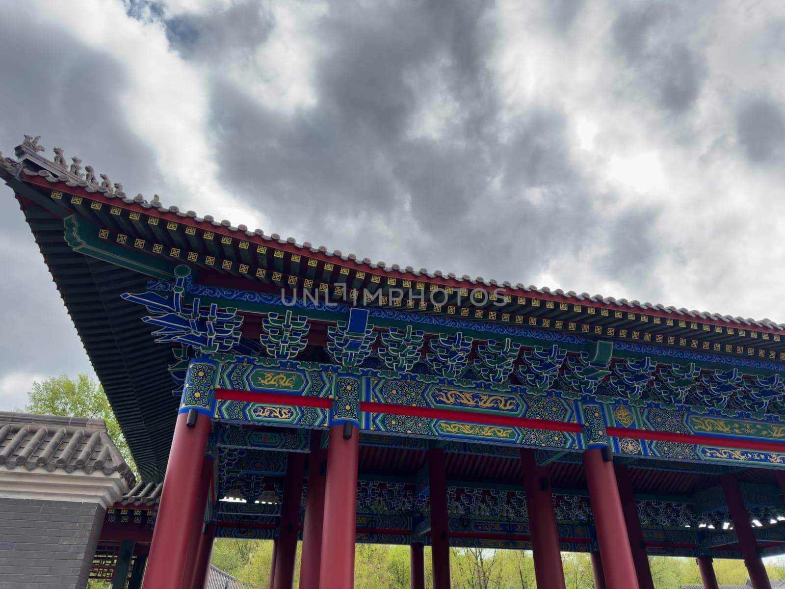 Close up view of the richly decorated roof structure of a traditional Chinese pavilion with vivid colors, intricate woodwork, and symbolic patterns, highlighting cultural architectural craftsmanship
