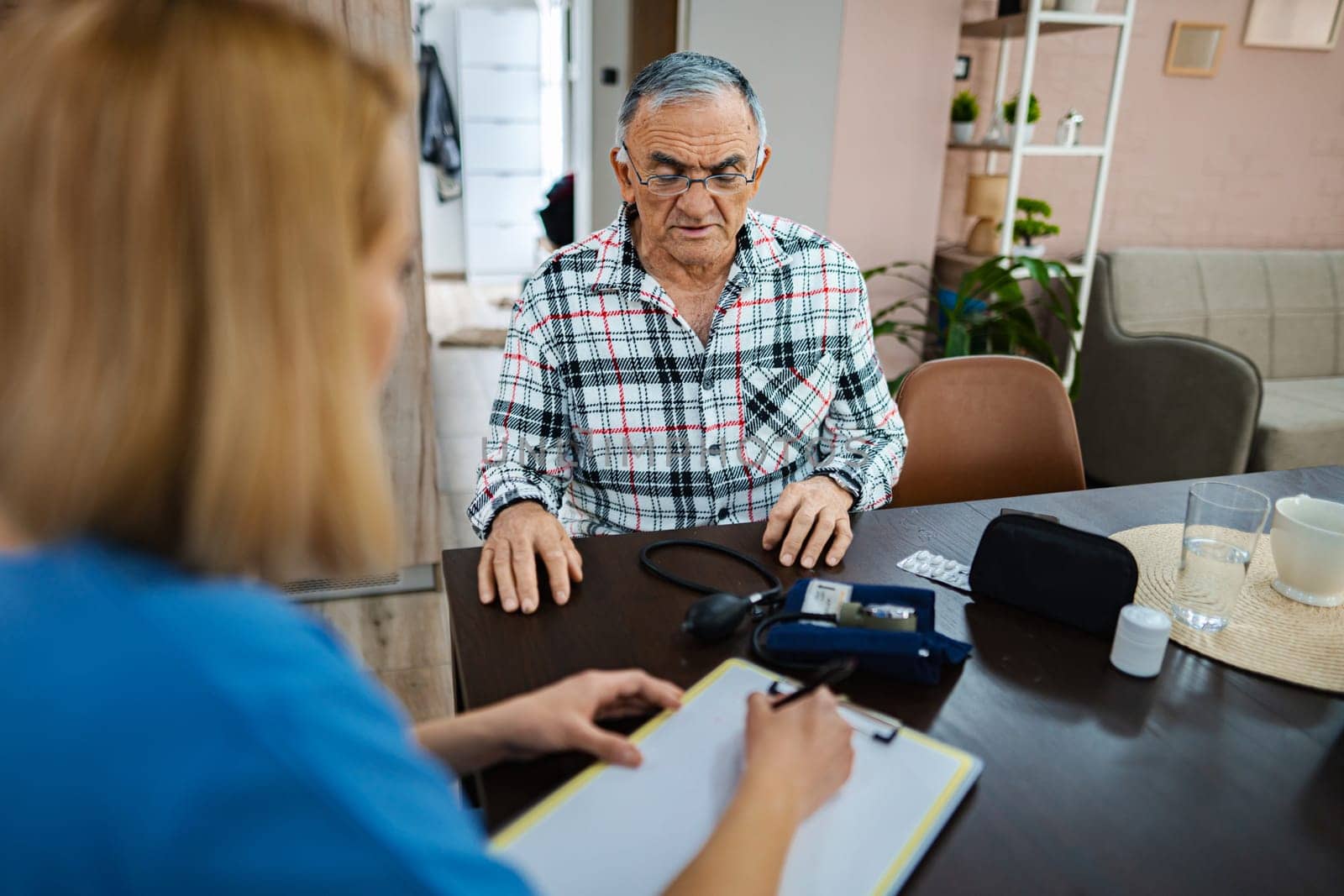 Health professional conducts a checkup with an elderly client.