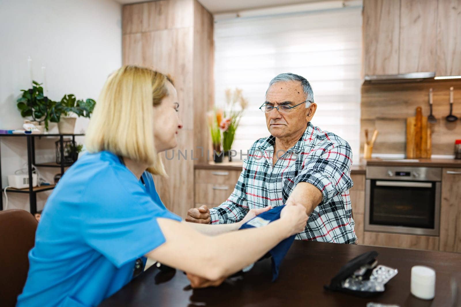 Nurse checks vital signs of senior patient at home.
