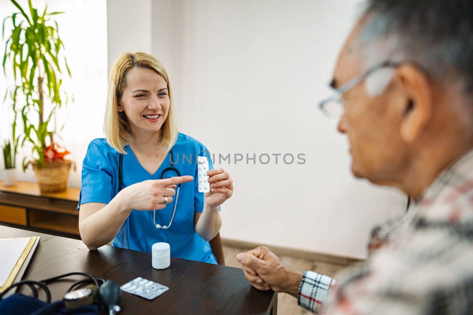 Nurse explains dosage instructions to elderly patient.