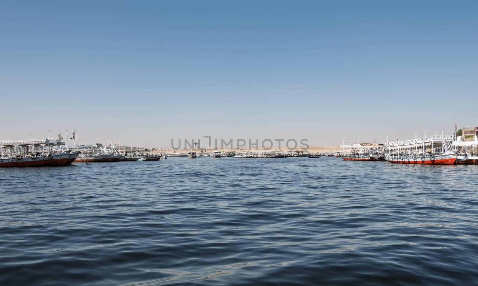 Aswan, Egypt - 5 November 2024: Many docked tour boats and ferries by the Old Aswan dam used to transport tourists to Philae Temple
