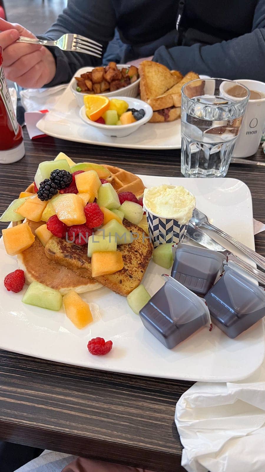Ottawa, ON Canada - 10.01.2024: Delicious Breakfast Platter with Fresh Fruit, Waffle, and Pancakes at a Restaurant Table