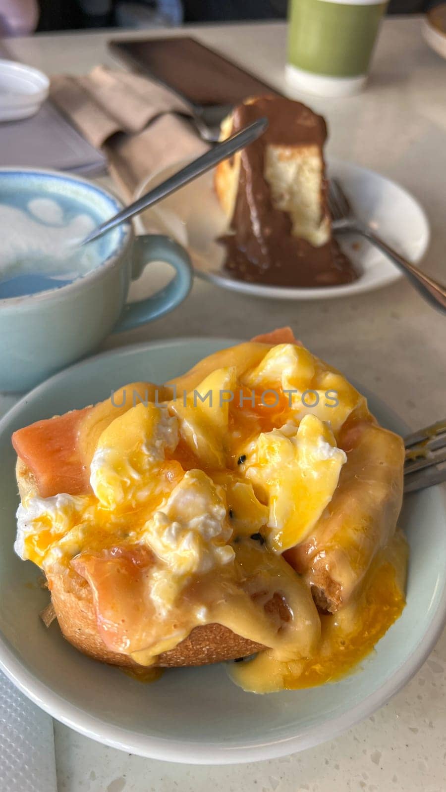 A beautifully plated Eggs Benedict with poached eggs, smoked salmon, and rich hollandaise sauce. Served with a decadent chocolate cheesecake, perfect for brunch or dessert lovers.
