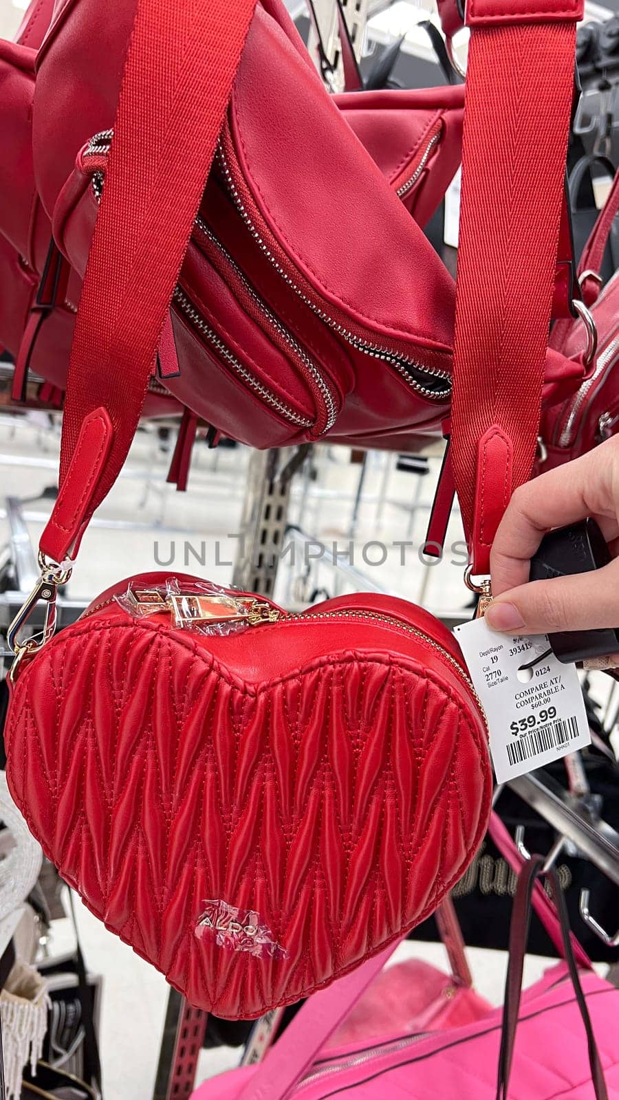 Ottawa, ON Canada - May 01, 2025: Stylish red heart-shaped handbag with Aldo logo displayed in a retail store, showcasing modern design and luxury accessories for fashion enthusiasts and shoppers.