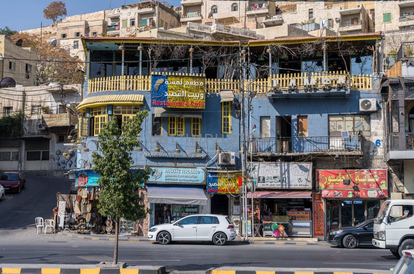 Amman, Jordan - 12 November 2024: Busy commercial block in downtown with shops and restaurants on hillside