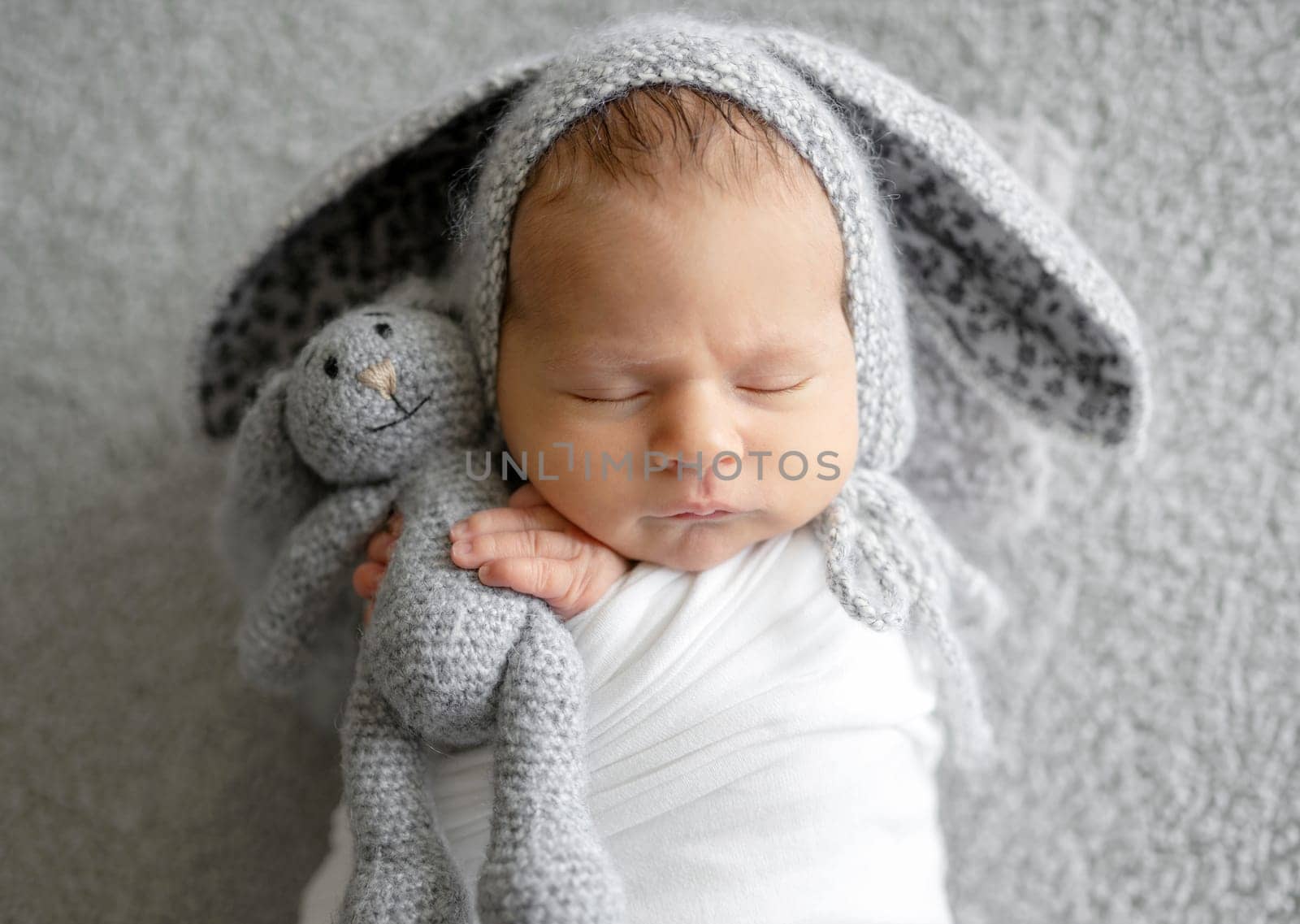 Newborn Baby Sleeping In A Bunny Hat In A Studio Photo
