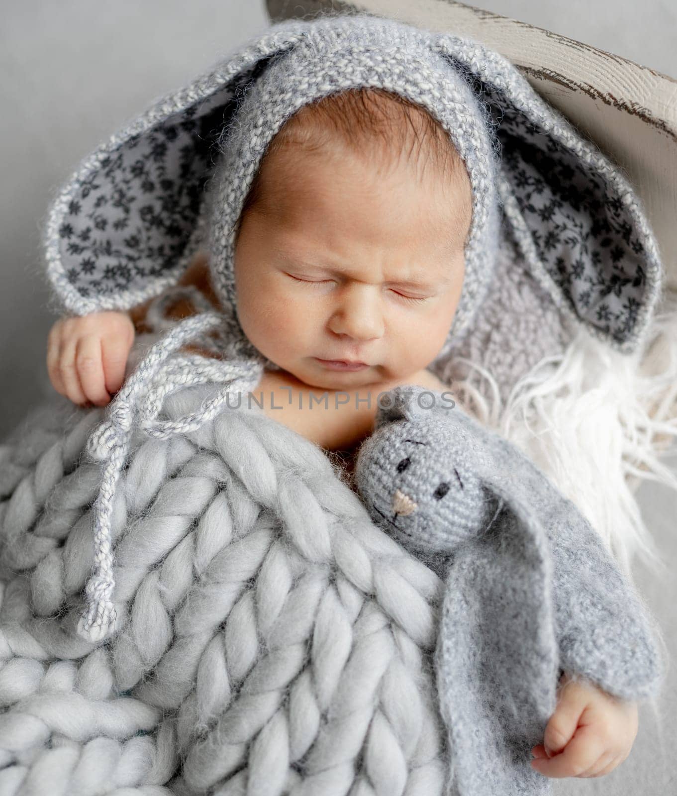 Newborn Baby Sleeping In A Bunny Hat In A Studio Photo