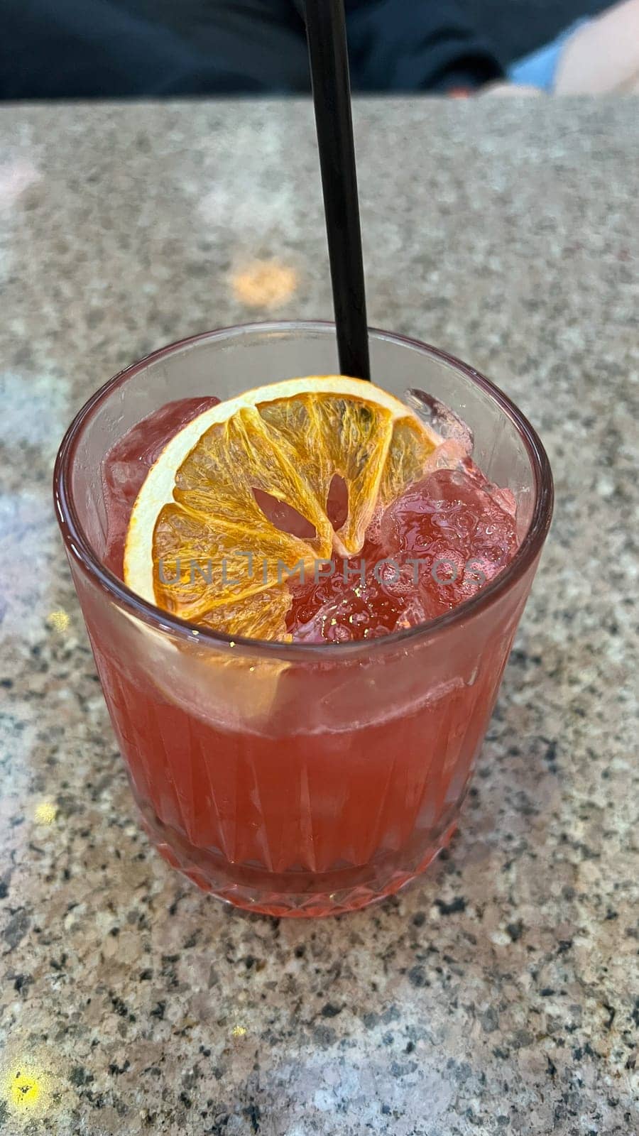Indulge in a vibrant cocktail drink featuring crushed ice, a straw, and a decorative orange slice. A thirst-quenching beverage to savor during sunny getaways or moments of pure relaxation. Enjoy