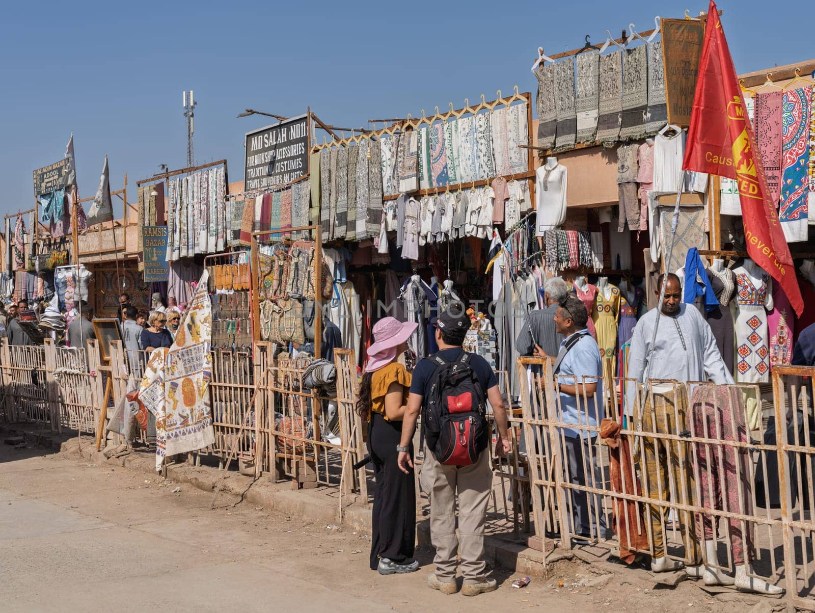 Edfu, Egypt - 6 November 2024: Tourists walking past shops outside the entrance to the temple in Edfu