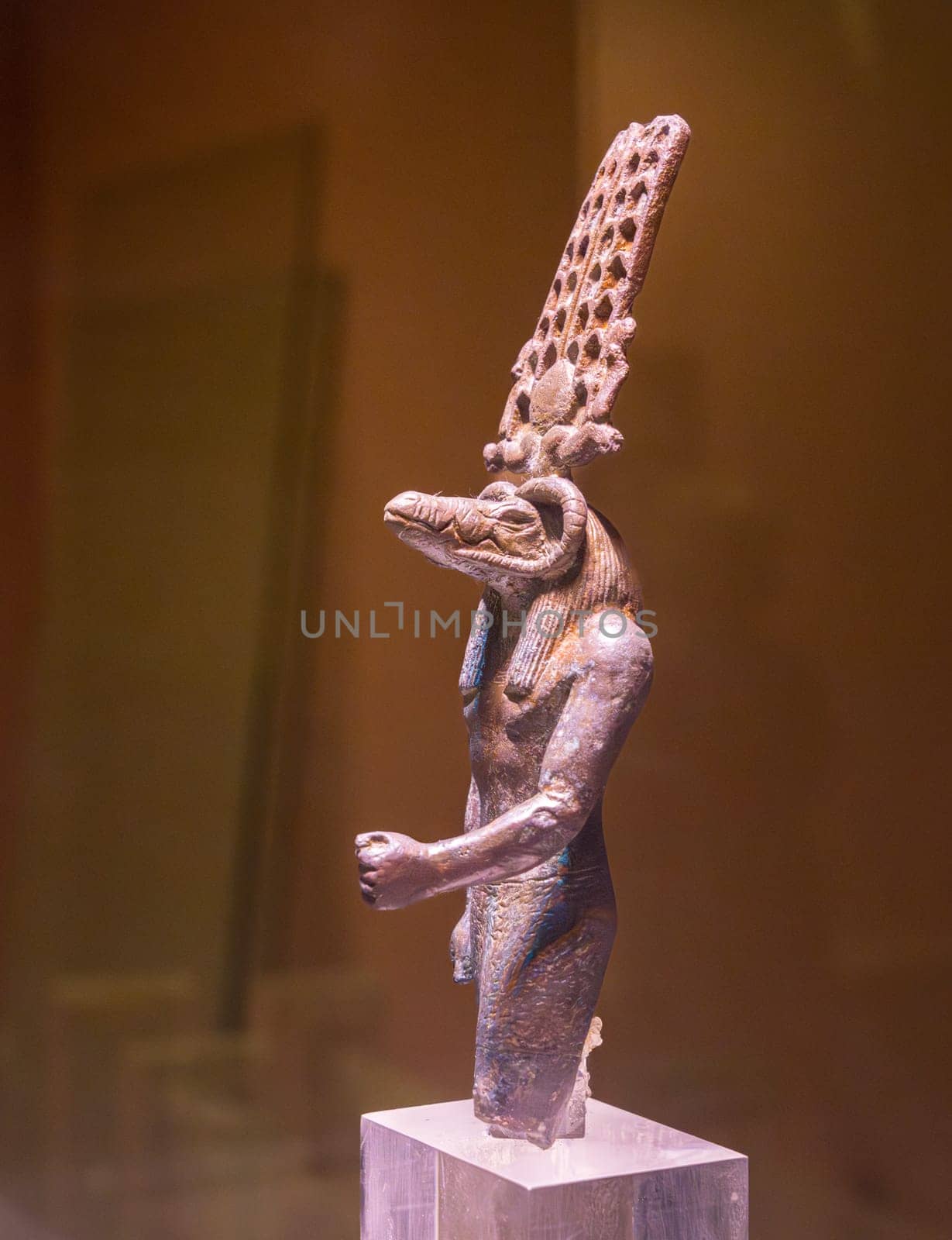 A detailed bronze statue of Sobek, the crocodile-headed god, from Kom Ombo, Egypt, displayed on a clear plinth