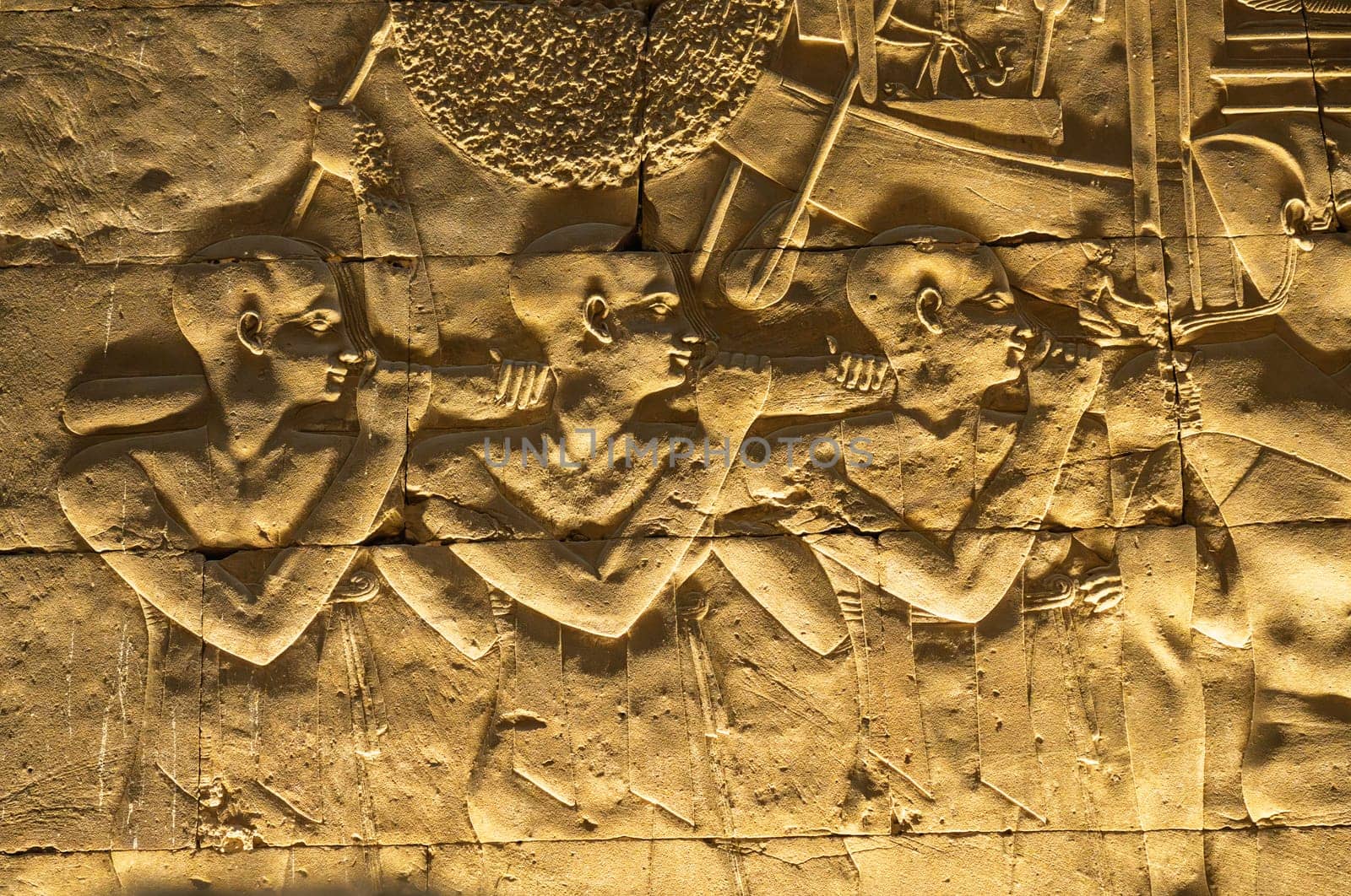 Detail of the carved images inside Edfu temple showing slaves carrying funeral boat and the many layers in bas-relief sculpture