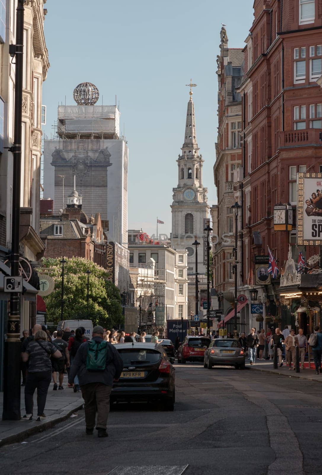 London, UK - May 13, 2025 - A crowd of people and tourists are walking on St Martin's Lane with Scenery view of St Martin-in-the-Fields and Ancient buildings. use it as your Wallpaper, Poster and Space for text, Selective focus.