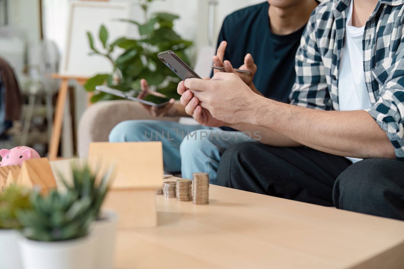 Two diverse young adults engaging in a financial planning discussion, showcasing collaboration in managing savings and investments in a cozy home environment.