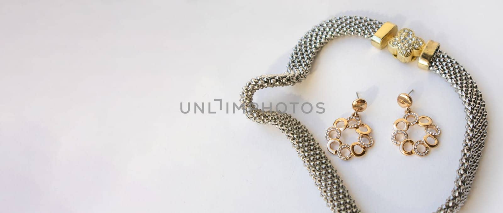 Banner with romantic jewelry set of sterling silver choker necklace and round chain earrings on white background, copy space.