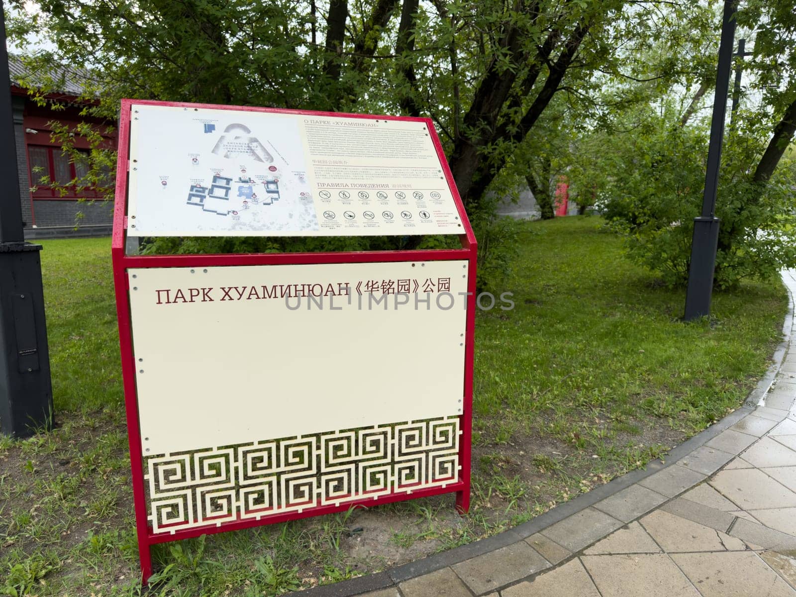 Moscow, Russia, April 25, 2025: Information stand with map and visitor rules at Huamin Park in Moscow features bilingual text in Russian and Chinese and decorative Asian style design