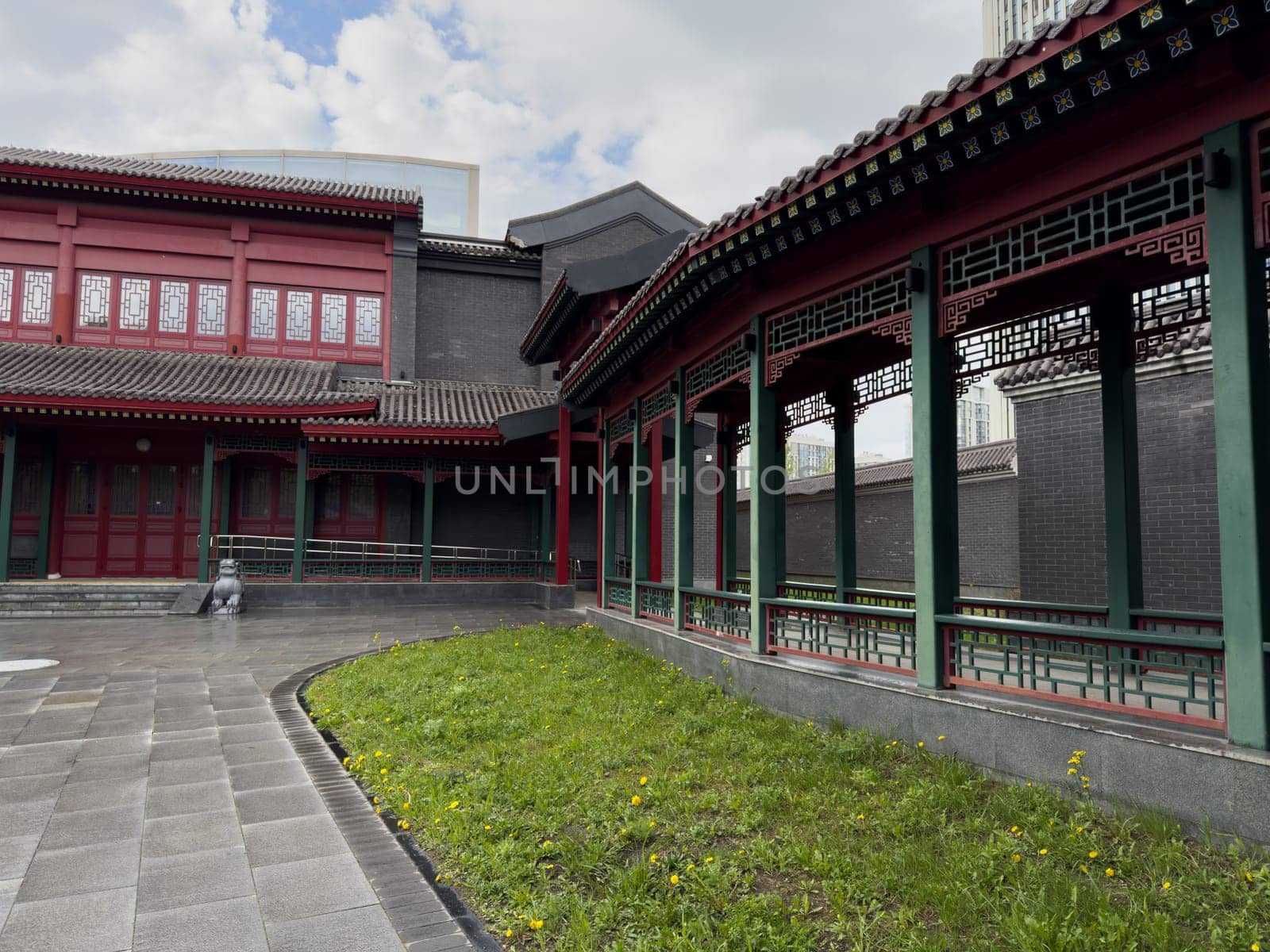 Moscow, Russia, April 25, 2025: Red building with arched roof and traditional Chinese latticework gallery located in Huamin park, highlighting cultural architecture and public space design in Moscow