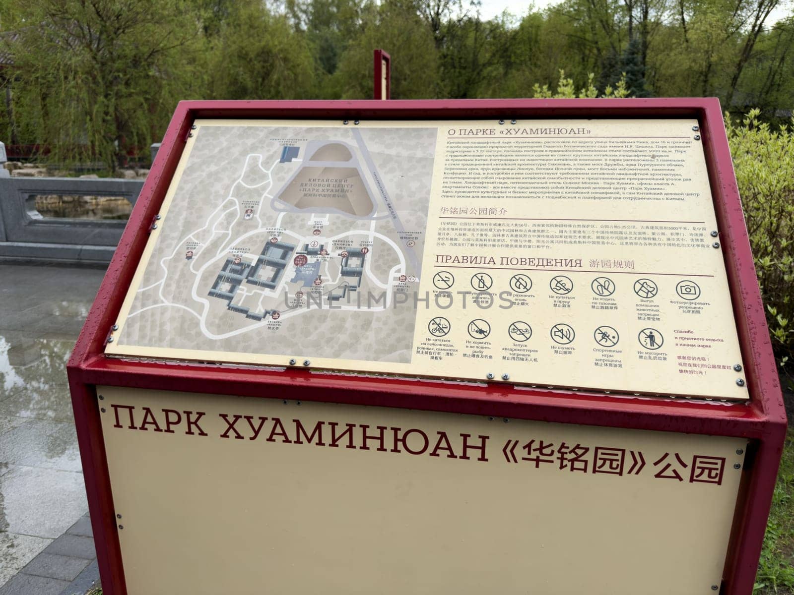 Moscow, Russia, April 25, 2025: Informational board with map and visitor rules at Huamin park in Moscow, designed in Chinese style and placed near scenic landscape and traditional architecture