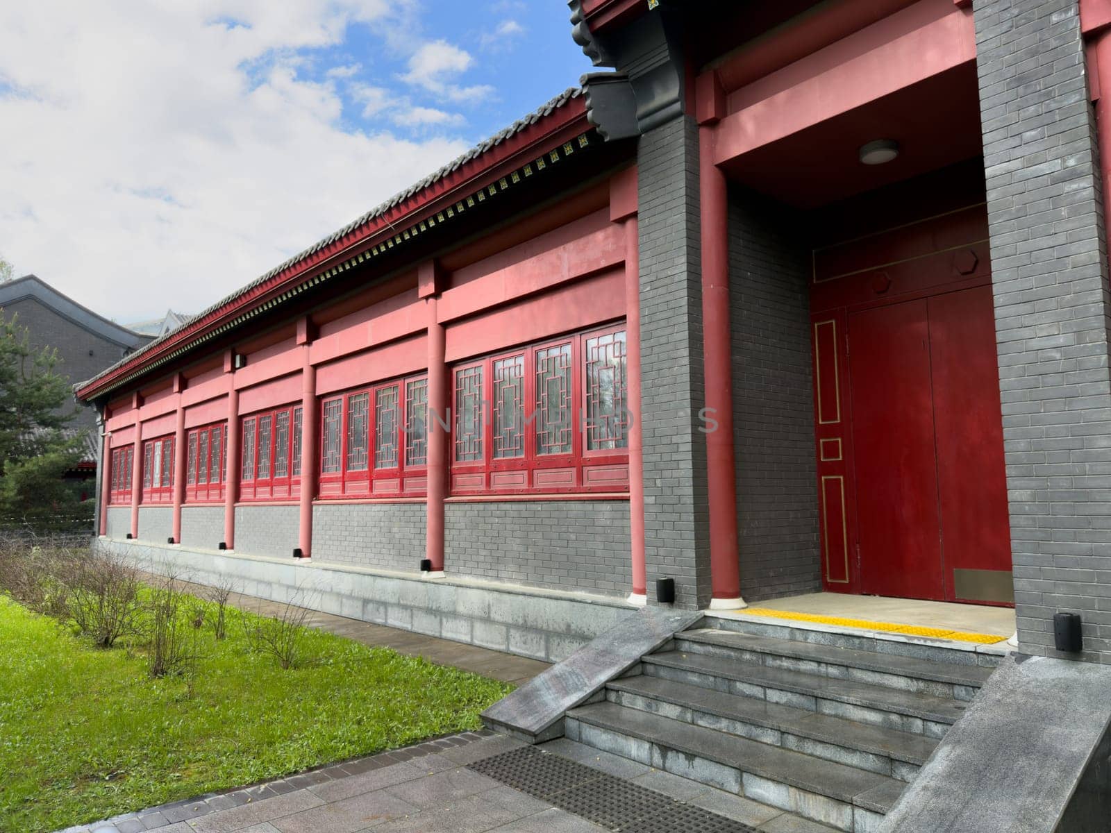 Moscow, Russia, April 25, 2025: Facade of traditional style. Chinese building in Huamin park shows influence of classical Asian architecture with decorative windows and tiled roof elements