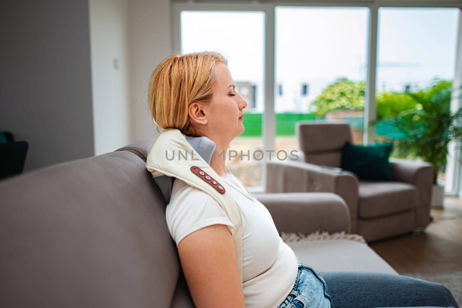 Woman enjoys a soothing break with neck support at home.