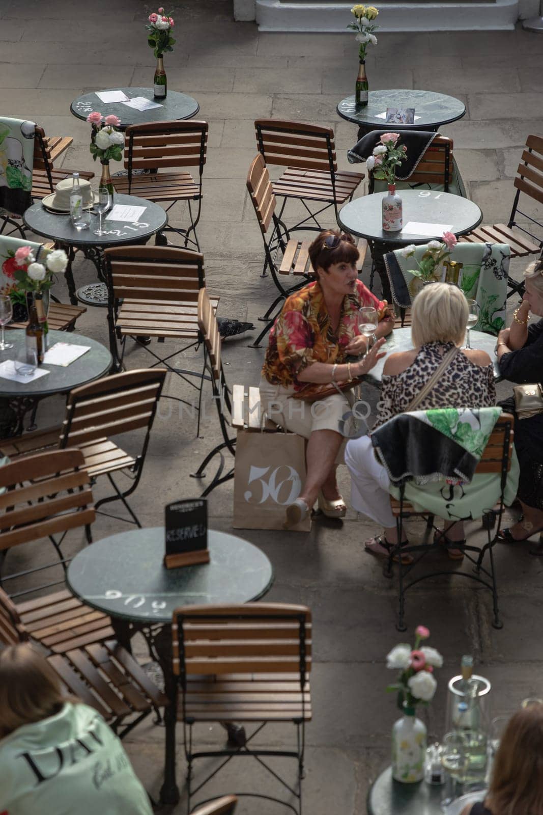 London, UK - May 13, 2025 - A group of women enjoying meeting up and drink together in a cafe area at Covent garden market, table and chairs, use it as your Wallpaper, Poster and Space for text, Selective focus.