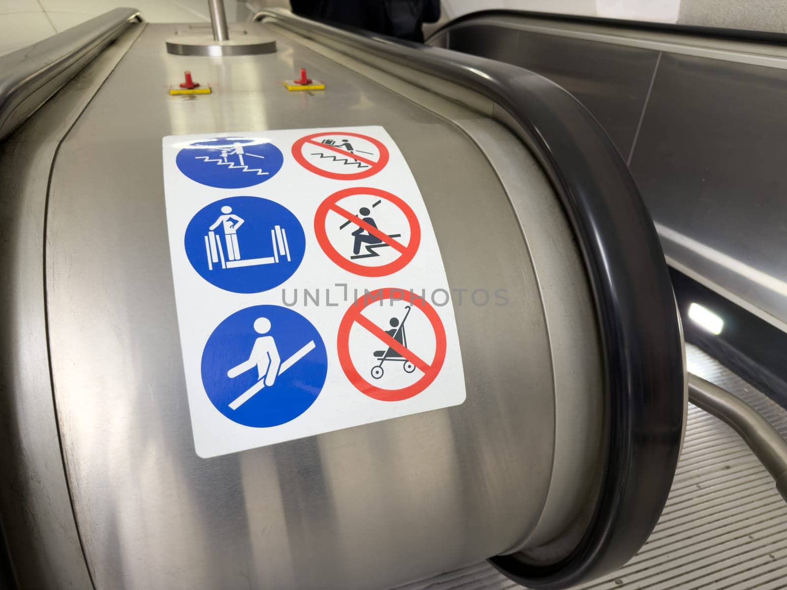 Escalator warning signs at metro or public transit station promote safety awareness and responsible passenger behavior in modern urban infrastructure environment
