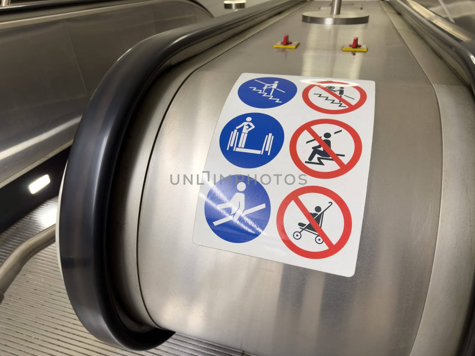 Close up of escalator safety instruction sign with multiple pictograms showing prohibited actions. Public transport safety concept with clear visual guidance for passengers
